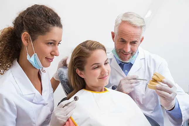 doctors telling a woman what to eat and avoid with dentures.