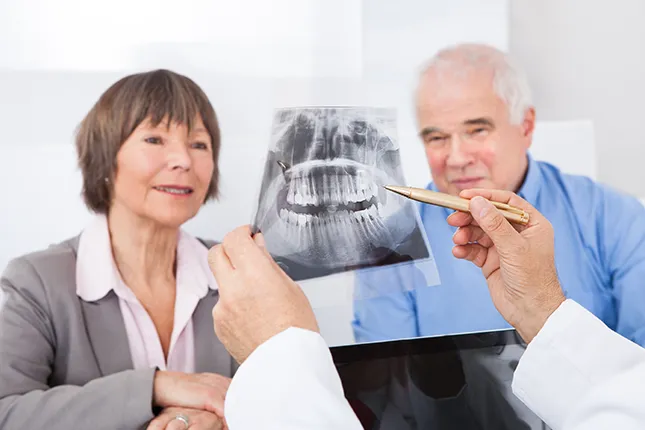 two old people learning about dentures